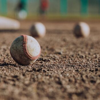 selective focus photography of white baseball balls on ground