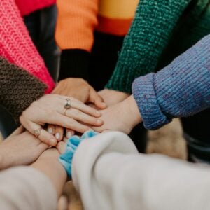 Community members stack their hands together