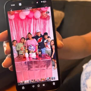 Wendys Martinez holds up her cell phone showing a photo of her husband, Carlos Moreno, and their children.