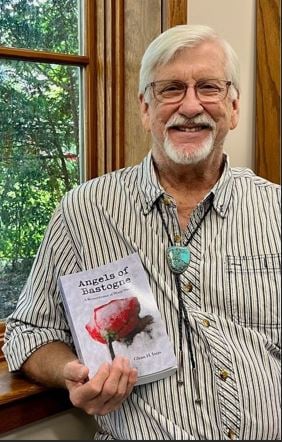 Author Glenn H. Ivers holding his book Angels of Bastogne