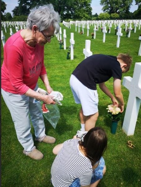The Senden family placing flowers at a grave in the Netherlands American Cemetery